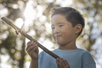 Мальчик держит палку с красочной бабочкой — стоковое фото