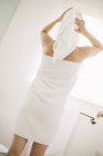 Donna in asciugamano bianco in un bagno — Foto stock