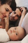 Mother, father and baby boy in bed — Stock Photo