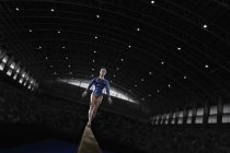 Жінка гімнастка виступає на промені — стокове фото