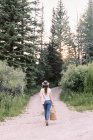 Femme marchant le long d'un sentier forestier — Photo de stock