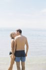 Casal em roupa de banho beijando em uma praia de areia — Fotografia de Stock