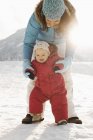 Mother and baby outdoors in the snow — Stock Photo