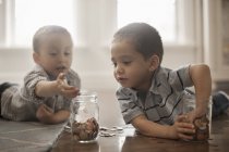 Двое детей играют с монетами — стоковое фото