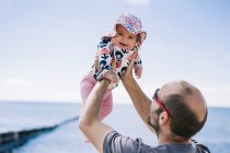 Padre sollevamento sua figlia bambino — Foto stock
