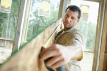 Homme mesurant la planche de bois — Photo de stock