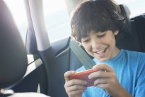 Хлопчик грає в ігри на смартфоні — стокове фото