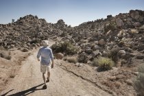 Uomo che cammina lungo un paesaggio roccioso — Foto stock