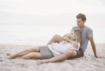 Coppia seduta vicino su una spiaggia — Foto stock