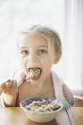 Girl eating breakfast from a bowl. — Stock Photo