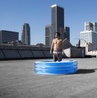 Uomo in piscina gonfiabile sul tetto — Foto stock