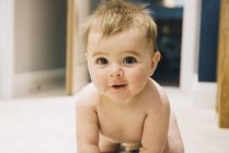 Baby crawling on a rug. — Stock Photo
