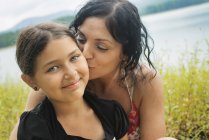 Madre e hija junto a una orilla del lago . - foto de stock