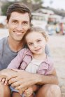 Young girl sitting on father's lap — Stock Photo