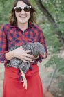 Woman holding a grey hen — Stock Photo