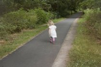 Giovane ragazza che cammina lungo un sentiero — Foto stock