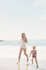 Femme avec fille sur la plage . — Photo de stock
