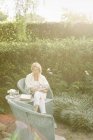 Woman sitting in a garden — Stock Photo