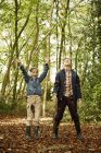 Girl and boy standing in woodland — Stock Photo