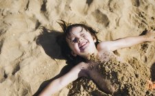 Garçon couché sur le dos sur la plage — Photo de stock