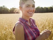 Жінка стоїть на пшеничному полі — стокове фото