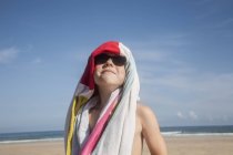 Garçon dans des lunettes de soleil avec une serviette — Photo de stock