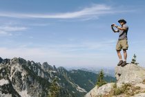 Excursionista en cumbre de montaña - foto de stock
