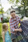 Father and daughter looking at a solar panel — Stock Photo