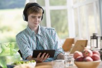 Хлопчик слухає музику з цифровим планшетом . — стокове фото