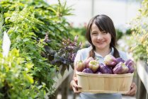 Girl with basket of bell peppers. — Stock Photo
