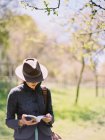 Frau mit Hut, liest ein Buch. — Stockfoto