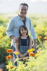 Hombre y una niña en un campo de flores . - foto de stock