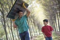 Hombre llevando un panel solar - foto de stock
