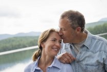 Couple standing by lake shore — Stock Photo
