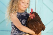 Chica sosteniendo pollo - foto de stock