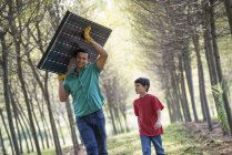 Homem carregando um painel solar — Fotografia de Stock