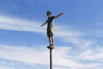 Homem balanceando em um poste de metal — Fotografia de Stock