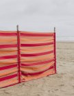 Red striped windbreak on Beach — Stock Photo