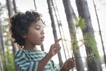 Enfant tenant une branche d'arbre — Photo de stock