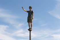 Homme équilibrage sur poteau métallique — Photo de stock