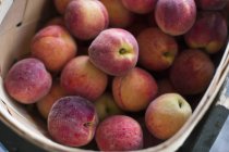 Crate of organic peaches. — Stock Photo