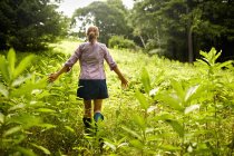 Woman walking through the undergrowth in woodland — Stock Photo