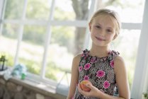 Girl holding a peach fruit — Stock Photo