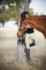 Mulher segurando cavalo por halter — Fotografia de Stock
