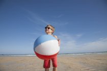 Хлопчик тримає великий пляжний м'яч . — стокове фото