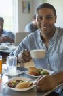Man eating and drinking in cafe — Stock Photo