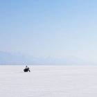 Motociclista montando sobre una superficie blanca plana - foto de stock