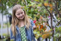 Girl looking at the peach tree. — Stock Photo