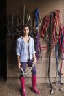 Woman standing in tack room — Stock Photo