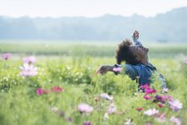 Жінка стоїть серед квітів — стокове фото